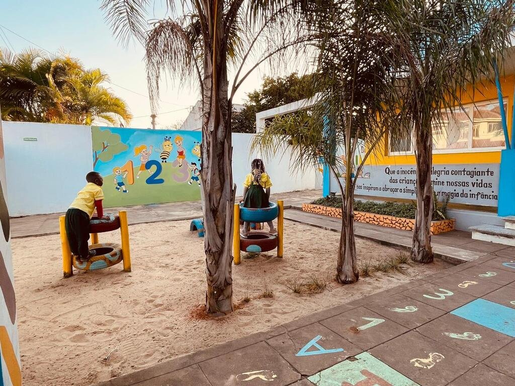 Pátio da Yume, com palmeiras e espaços para brincar