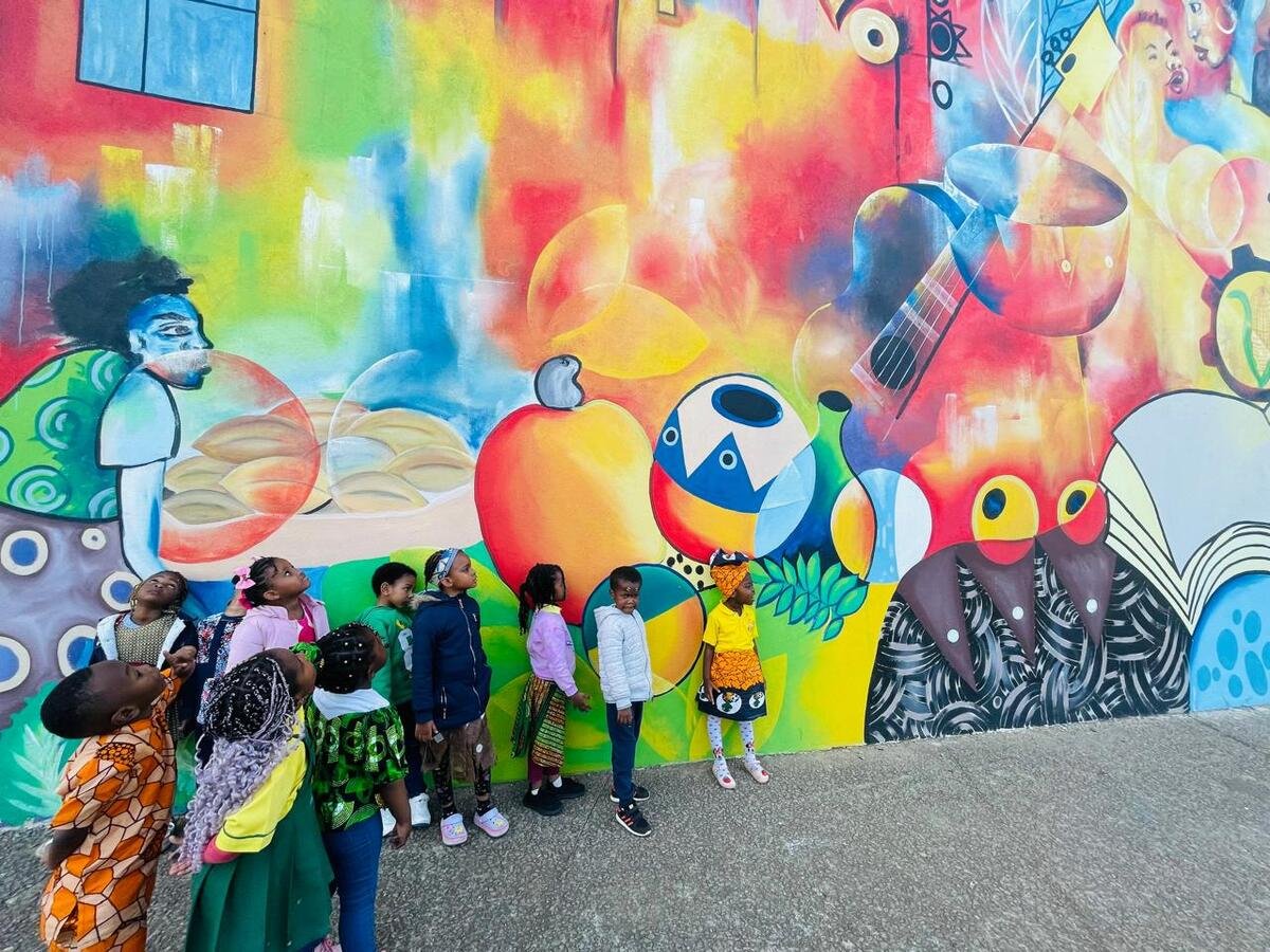 Crianças da Yume a brincar junto a um mural colorido